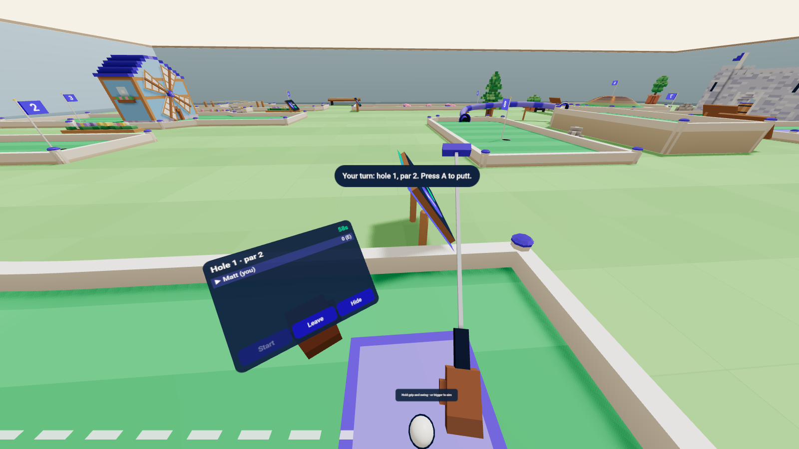 Mini golf in VR. The putter hangs from my right hand and the scorecard sits on my left wrist